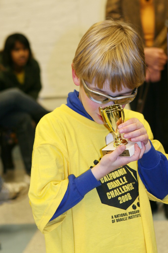 A Braille Challenge participant closely examines his trophy
