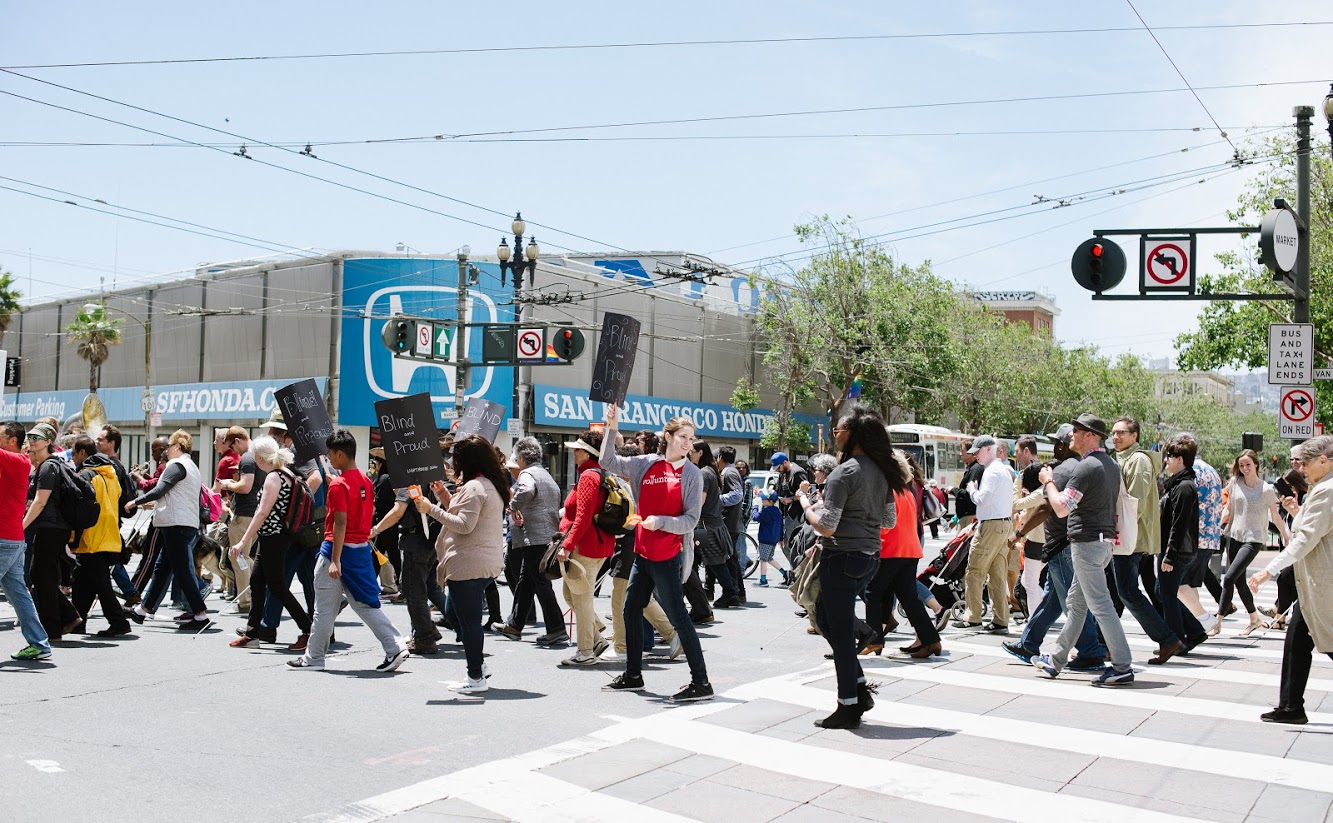 Hundreds of marchers in our Grand Opening Parade fill the street as they make the turn from Van Ness to Market Street and continue to our new headquarters building.