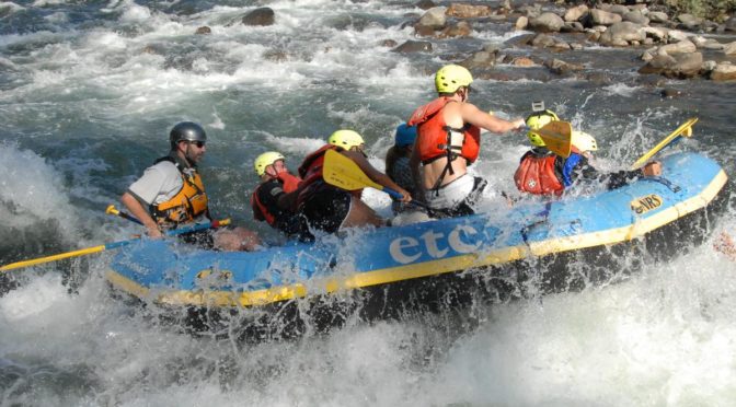 Group of whitewater rafters on a river.