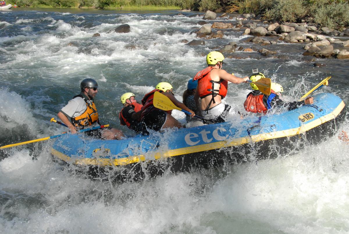 Group of whitewater rafters on a river.