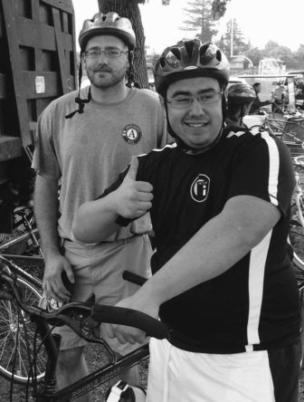 Anthony smiling, standing with his bike behind his tandem parter