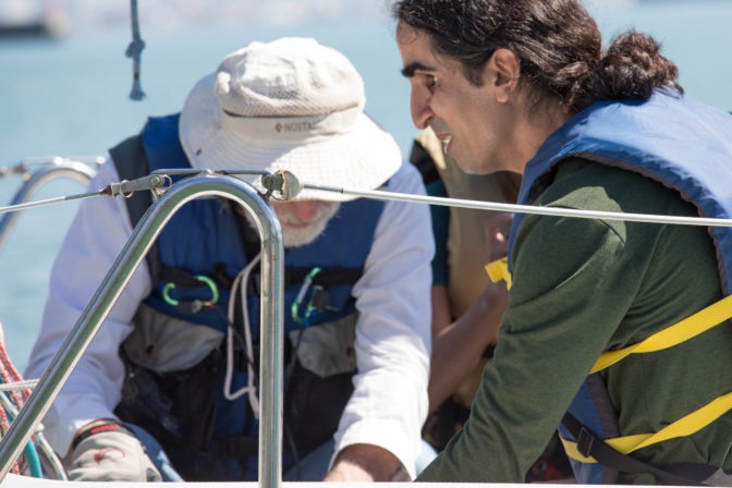 Ahmet shows his sonar navigation system to a fellow blind sailor named Ben.