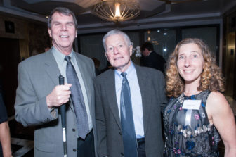 A trio of Gala attendees stand smiling.