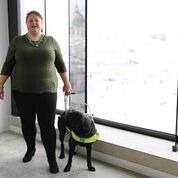 Lee Kumutat stands with her guide dog