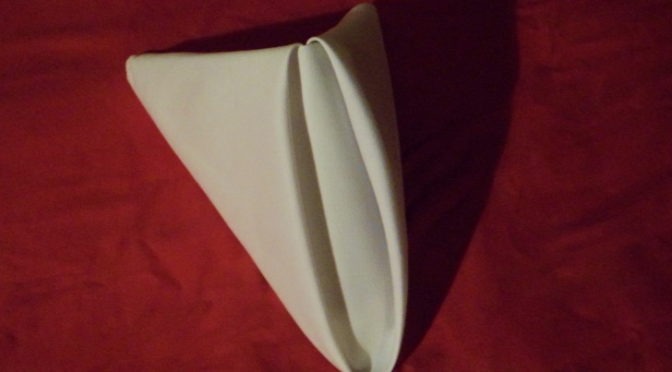 A napkin folded in pyrimad style.