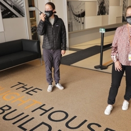 Two people wearing masks standing six feet apart in the LightHouse building lobby at 1155 Market Street