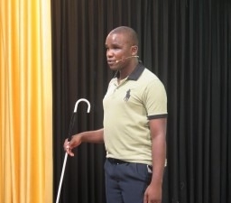 Robert Malunda standing with a white cane in his hand