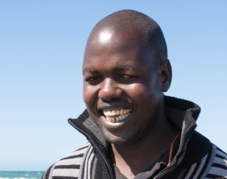 Ojok Simon smiles at the beach