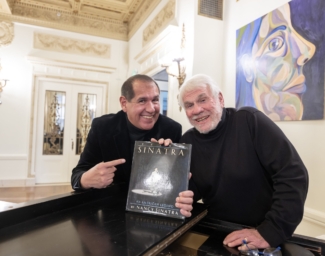 Alex and Steve smile and hold the book, Frank Sinatra: An American Legend by Nancy Sinatra. 