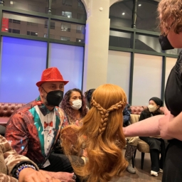 LightHouse student Carol touches a wig used in FROZEN the musical