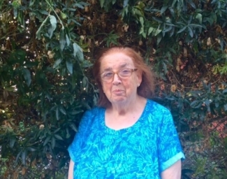 In front of a wall of leaves and flowers