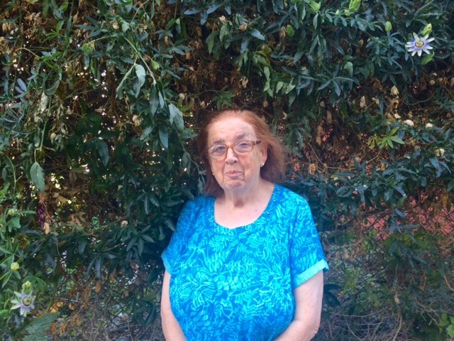 In front of a wall of leaves and flowers