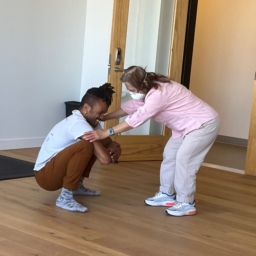 Gravity dancer, Gabrielle, Christian squats, and hold the hands of student Katlau, who bends over face-to-face and close up as they work together during and improvisational movement class.at LightHouse
