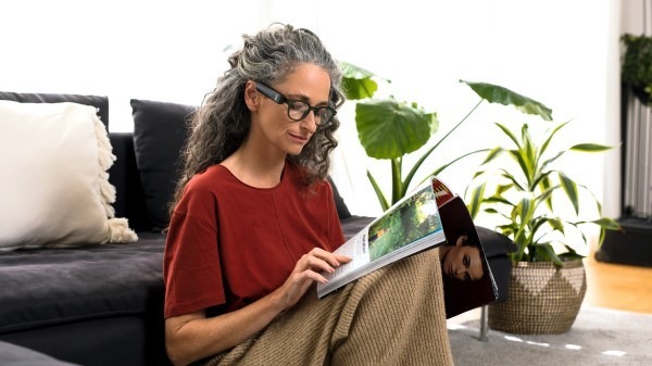 A woman using an OrCam MyEye to read a boo