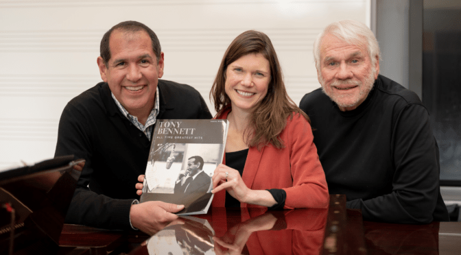 Alex Perez, Marie Finch and Steve Gill pose together holing a book about Tony Bennett