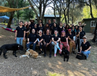 The EHC Summer 2023 Staff pose together at a picnic table at Enchanted Hills Camp in Napa