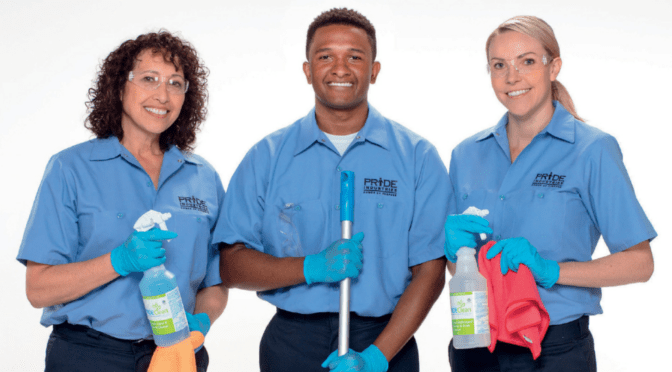 Three people wearing Pride Industries uniforms. The middle one holds the handle of a mope when the two at either end hold PrideClean products