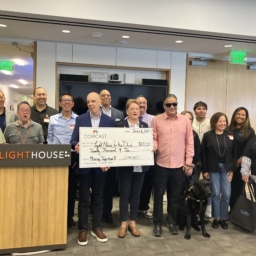 LightHouse staff and the Xfinity Accessibility team pose together at the LightHouse HQ with a giant check for $20k.