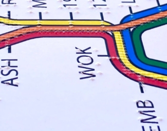 A finger explores a tactile BART system map.