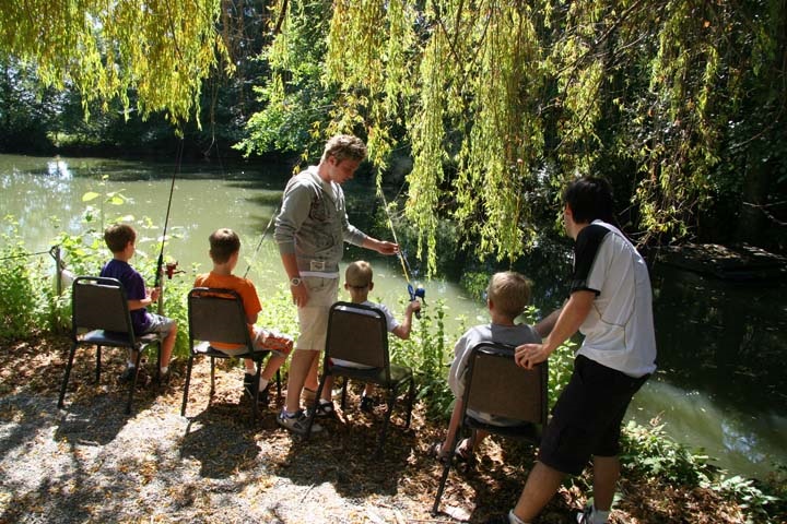 Counselors and campers fishing in Enchanted Hills' beautiful lake