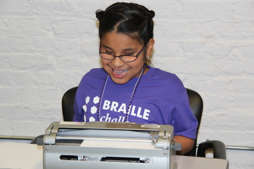 Young girl typing on a Perkins Brailler during last year’s Braille Challenge