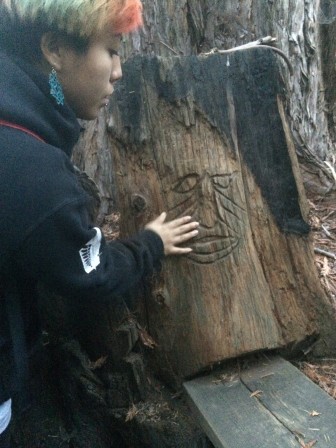 An OEI student explores a tree carving tactilely.