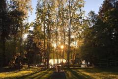Early morning sun filters through the lake side trees at Enchanted Hills Camp.
