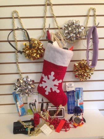A red and white stocking filled with accessible gifts and surrounded by gold and silver ribbons.