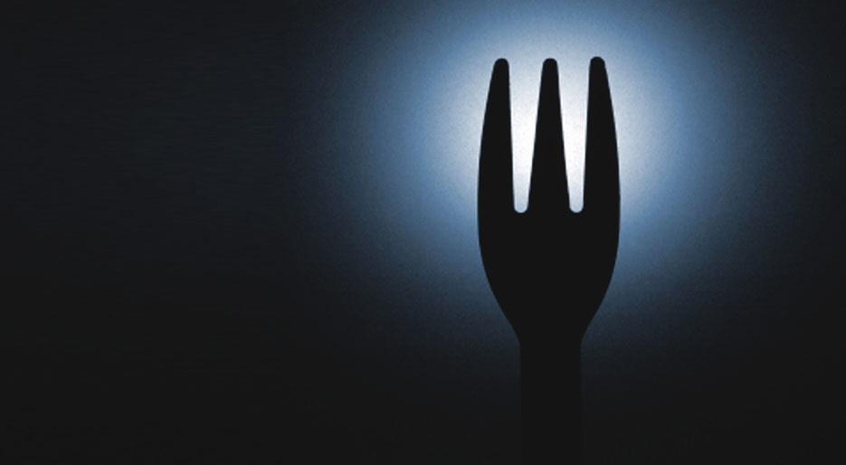 A picture of a fork silhouetted in the dark