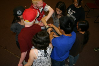 Students practice communicating as they attempt to undo themselves from a human knot
